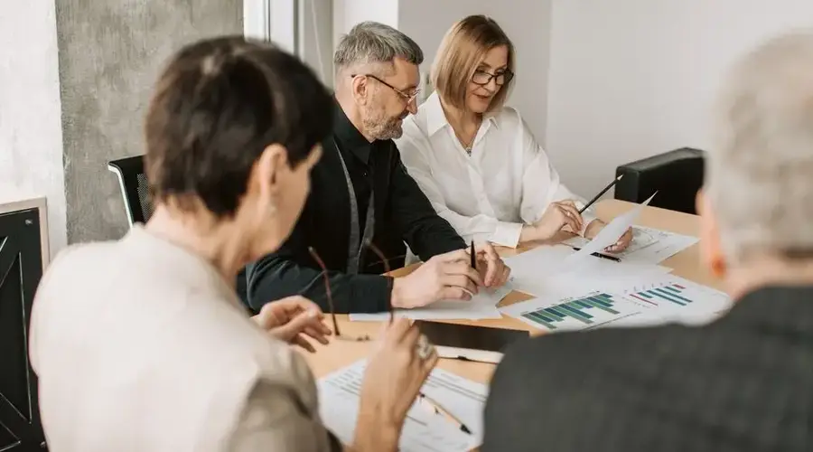 Team of professionals in office analyzing financial documents for business strategy.