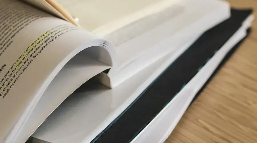 A pile of open books on a table, ideal for study and research themes.