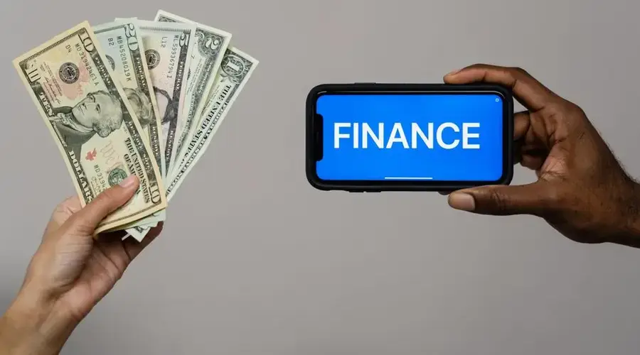 Image depicting currency and finance concept with hands holding cash and a smartphone.