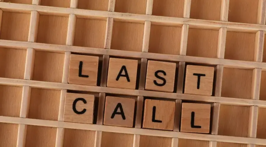 Wooden letter tiles forming the phrase 'Last Call' on a wooden background.