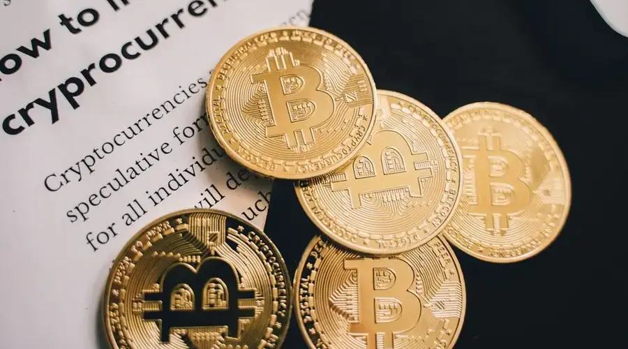 Close-up of Bitcoin coins alongside an investment guide in cryptocurrency.