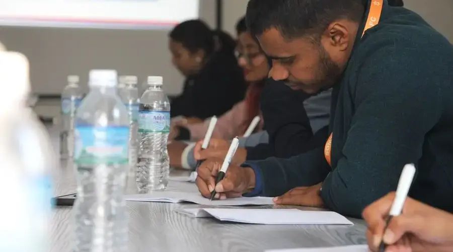 Focused students taking notes during a classroom seminar indoors.