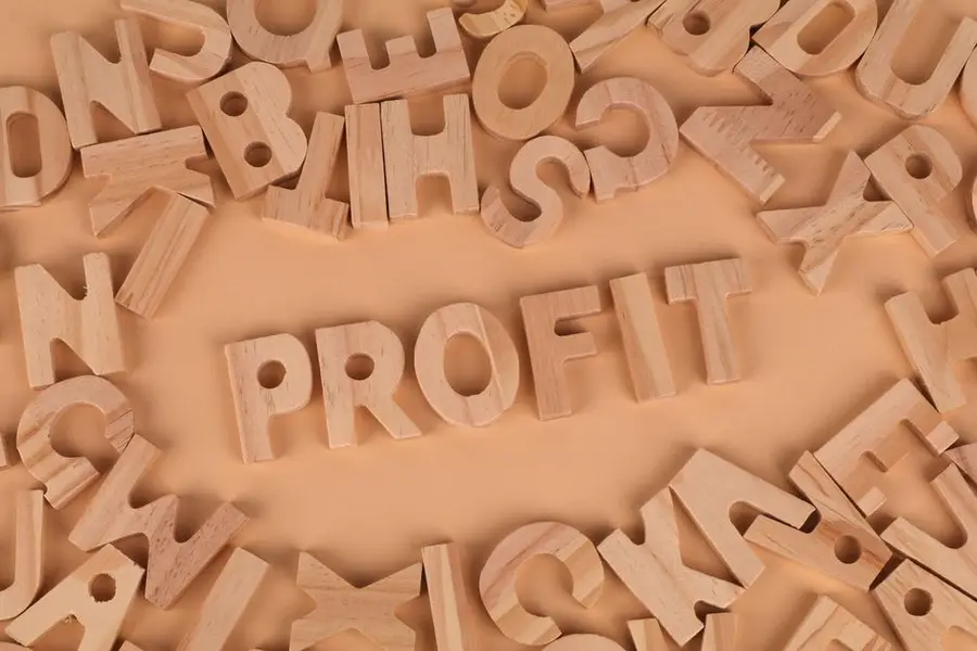 Wooden letters scattered on a table with 'PROFIT' prominently displayed.