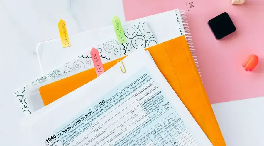 Overhead view of tax documents, forms, and organized work area for tax preparation.