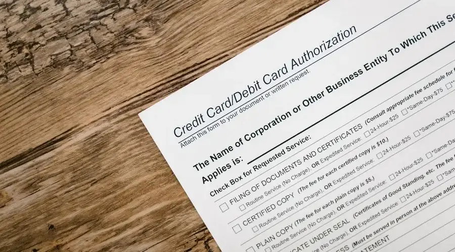 A credit card authorization form placed on a wooden desk, highlighting business paperwork essentials.