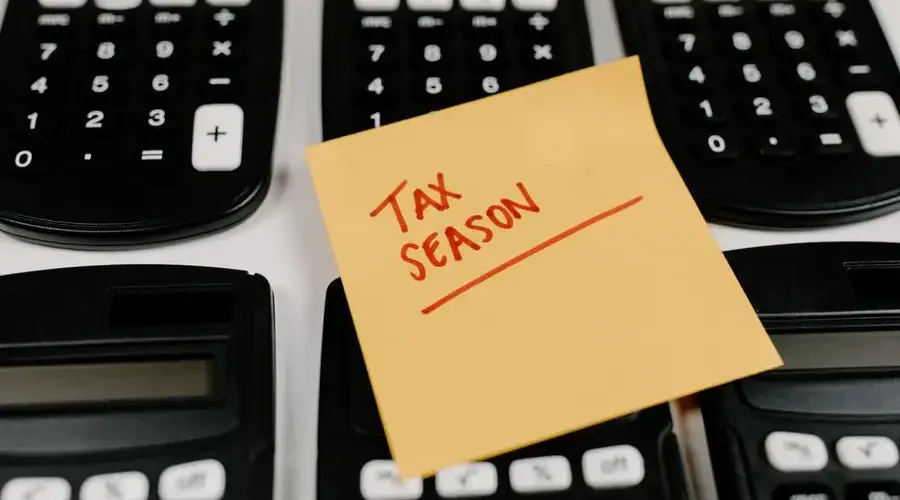 Close-up of calculators and a sticky note labeled 'Tax Season', symbolizing tax preparation.