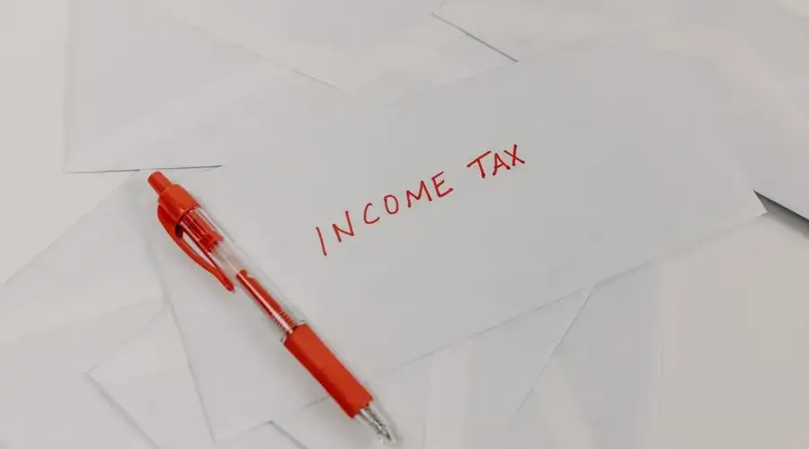 Studio shot of income tax envelope with red pen for accounting and tax season preparation.