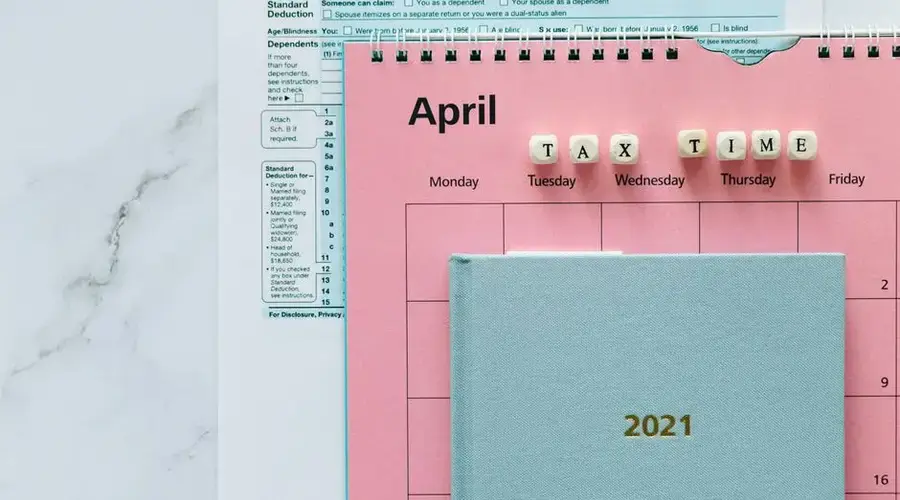 April calendar with tax forms, highlighting tax time reminders for financial tasks.