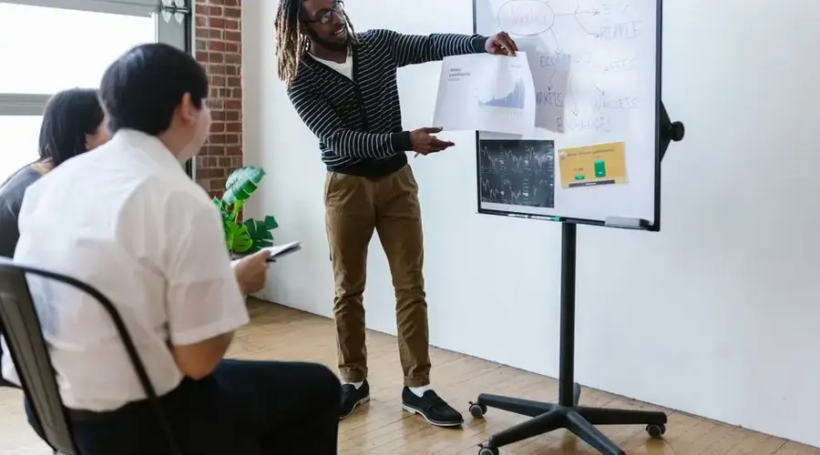 Professionals engaged in a cryptocurrency strategy session with visual aids on a whiteboard.