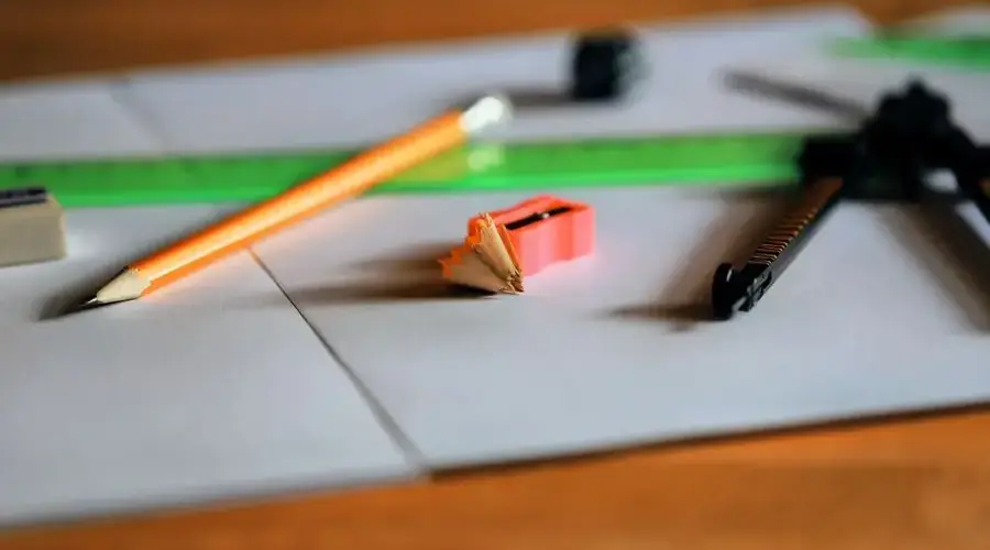 A close-up view of stationery essentials including pencil, sharpener, eraser, ruler, and compass.
