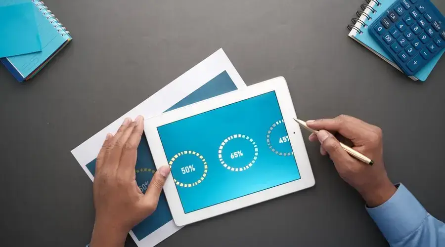 A professional reviewing statistical data on a digital tablet. Top view of business analysis.