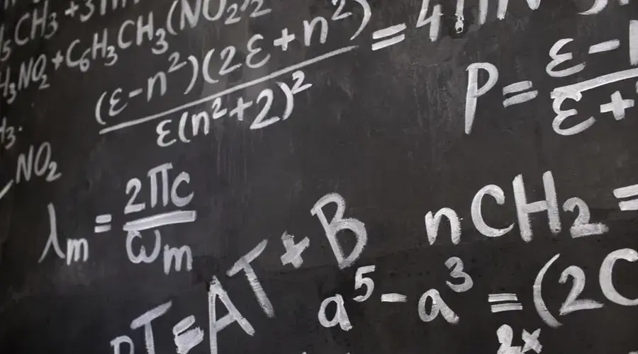 Close-up view of a blackboard filled with complex mathematical equations and formulas.