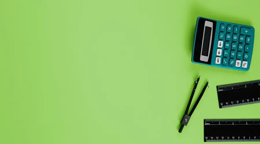 Calculator and drawing tools on a vibrant green background with ample copy space.