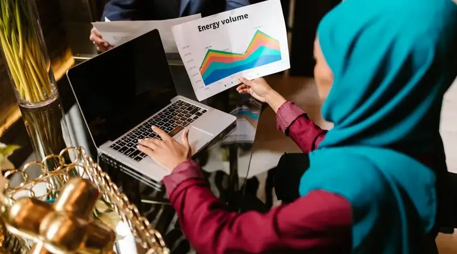 Muslim woman analyzing energy volume data during a business meeting.
