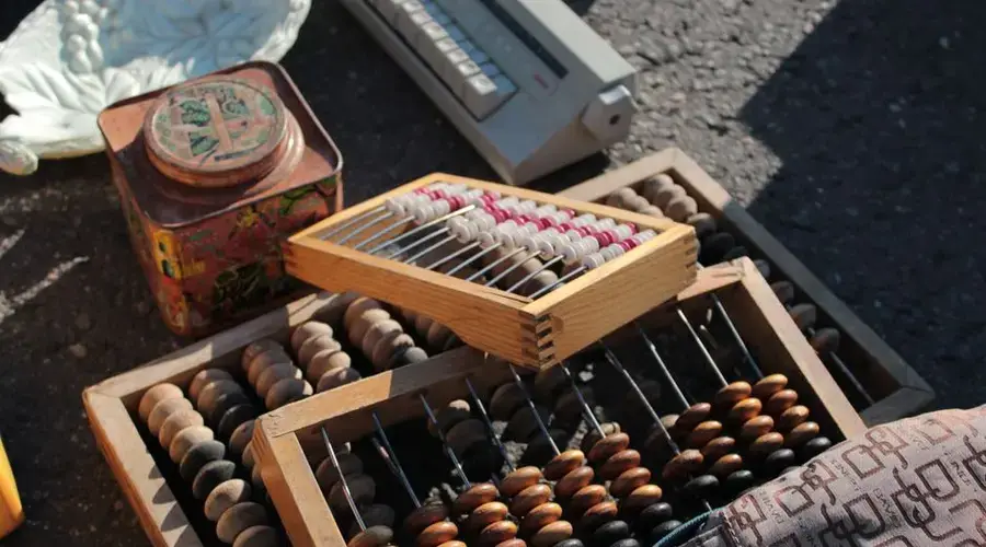 Collection of vintage abacuses and retro items on a sunlit surface.