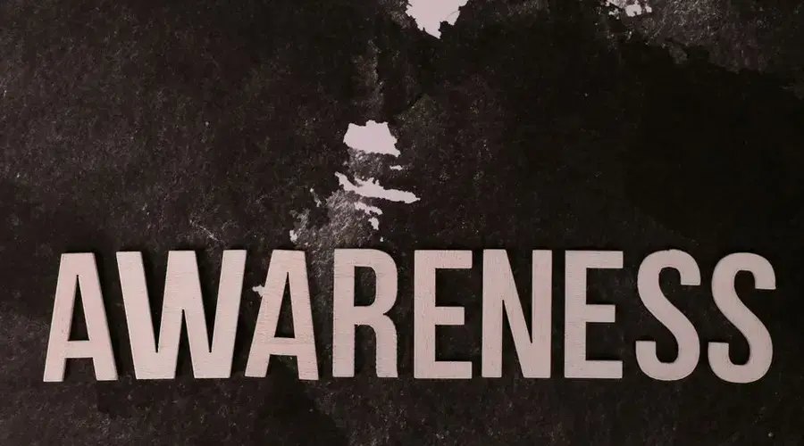 Text 'Awareness' on a dark textured backdrop promotes mindfulness and social causes.