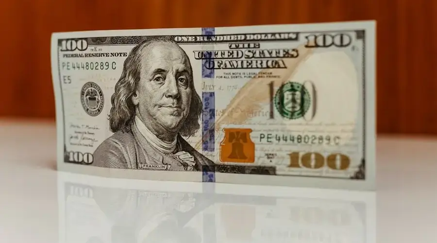 Detailed image of a US one hundred dollar bill featuring Benjamin Franklin.
