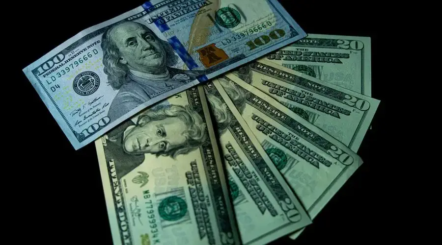 Close-up image of varied US dollar bills on a black background.