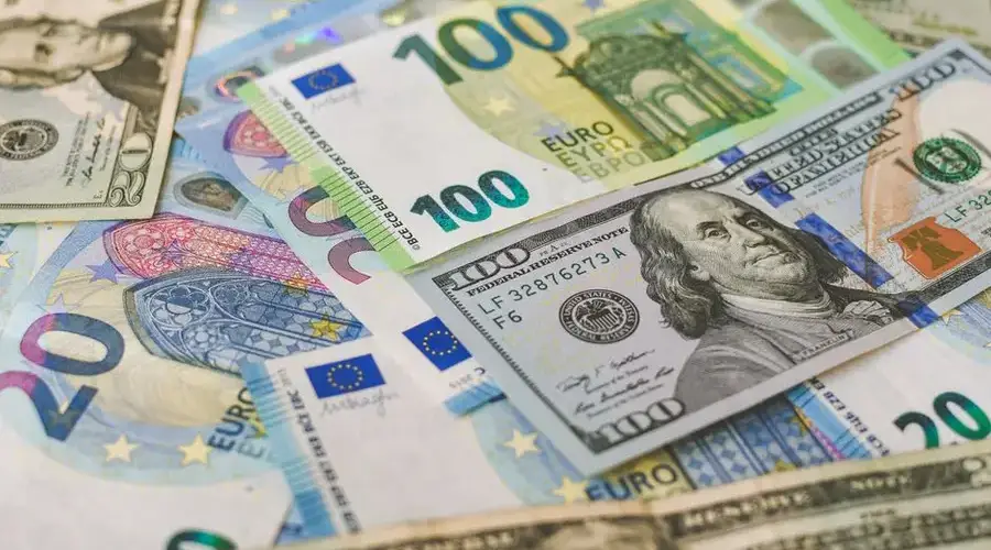 A detailed image of Euro and US dollar banknotes scattered, symbolizing global currency exchange.