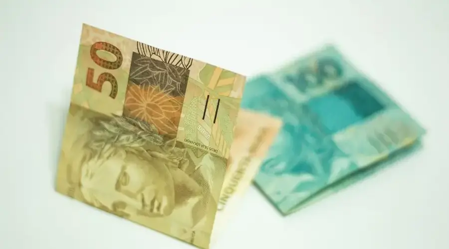 A close-up shot showcasing Brazilian banknotes, featuring 50 and 100 real bills.