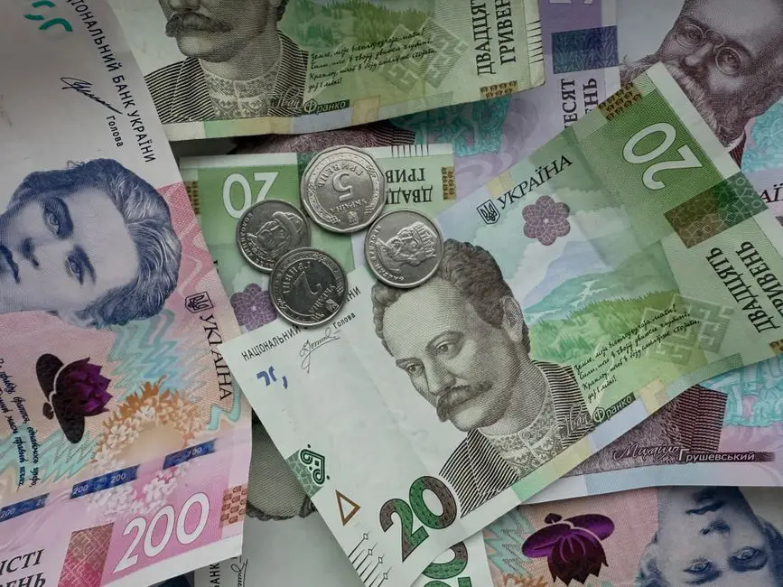 Closeup of various Ukrainian hryvnias and coins, showcasing currency details.