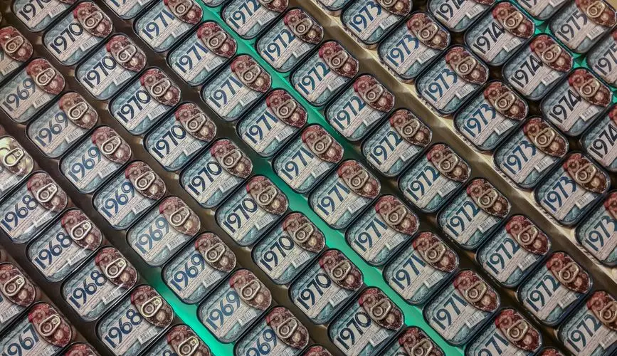 Rows of vintage sardine cans on display, showcasing various years in a Porto shop.