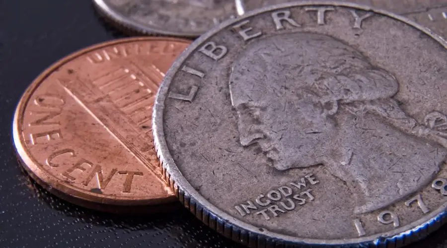 Detailed close-up of a US quarter and penny highlighting currency texture.