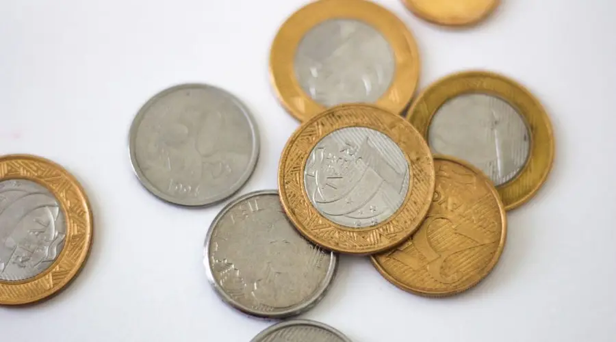 Detailed close-up of Brazilian coins displaying various denominations on a clean white surface.