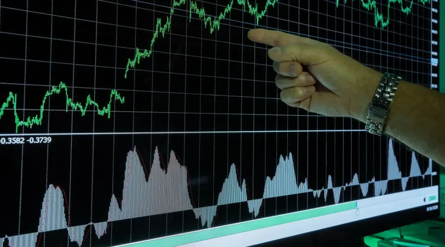 Graph showing financial data analysis with a hand pointing out market trends.
