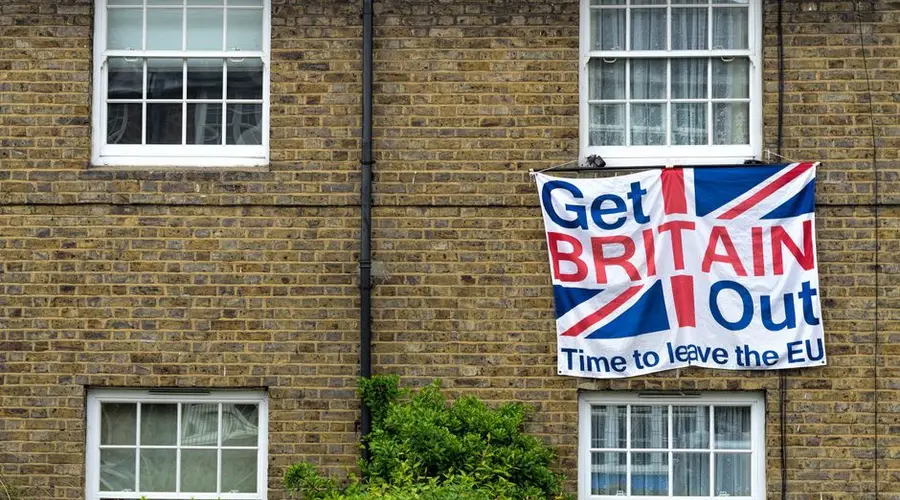 Brick home displaying Brexit protest sign with Union Jack design.