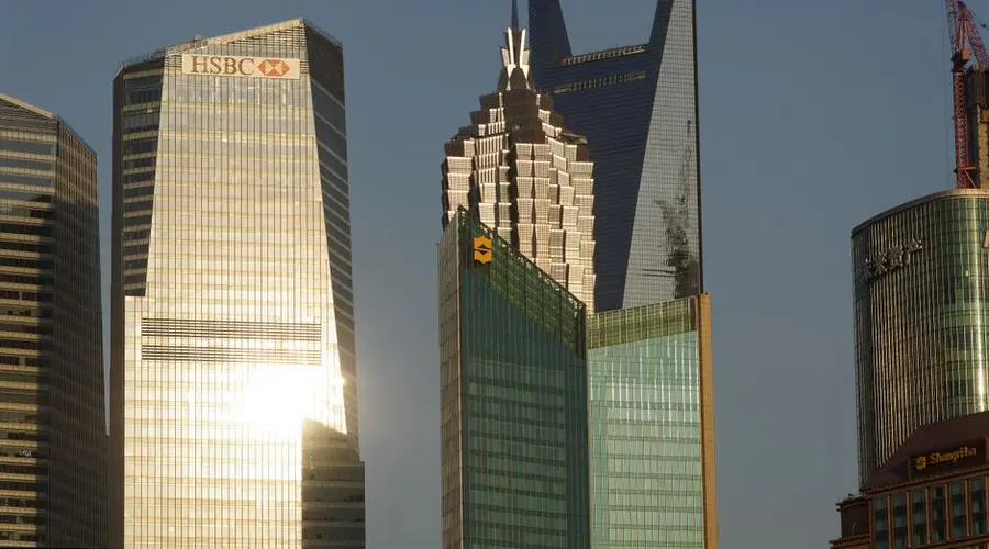 Glowing skyscrapers in Shanghai's financial district reflecting evening light.