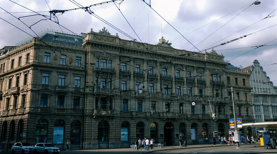 An ornate historic building in a city center with visible tram lines and street activity.