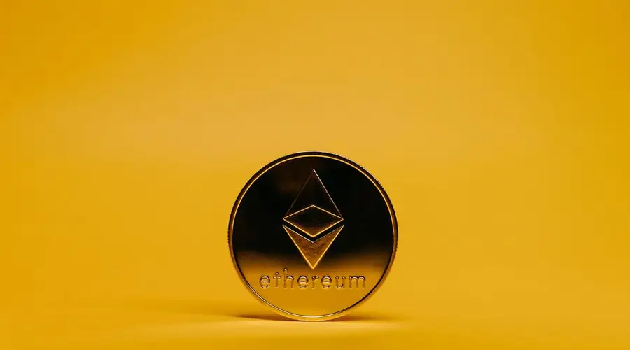A shiny Ethereum coin displayed on a vibrant yellow background, symbolizing cryptocurrency.