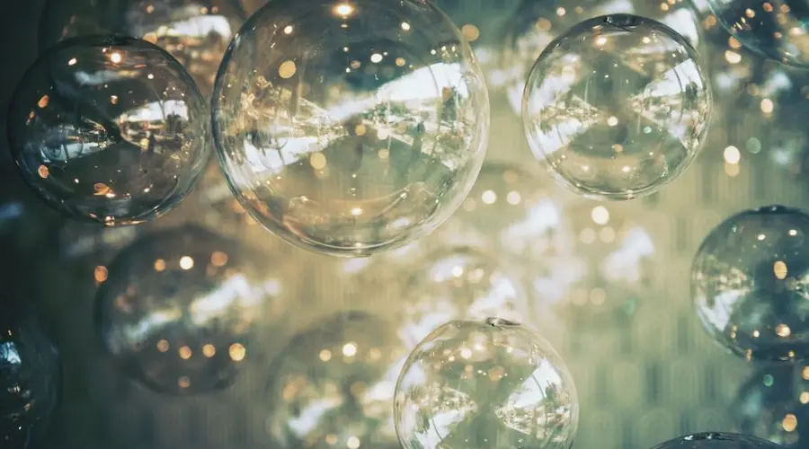 Elegant close-up of glass bubbles with reflections and bokeh, creating a dreamy atmosphere.