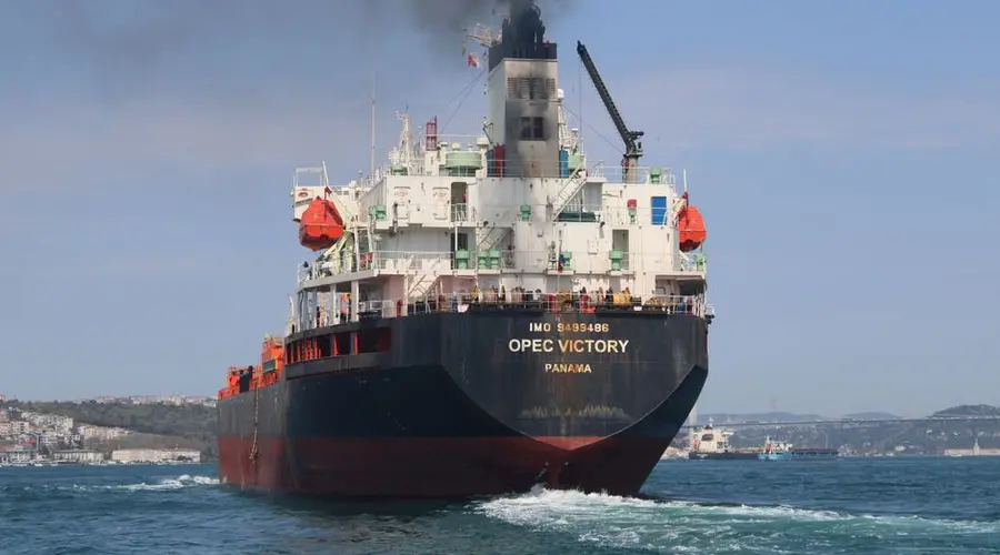 Oil tanker OPEC Victory sailing on the Bosporus under clear skies, emitting smoke.