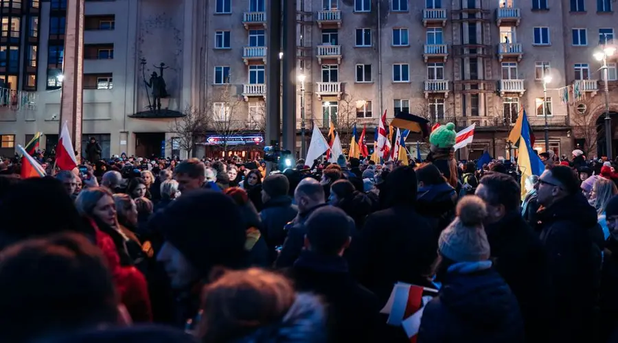 Crowd gathered peacefully in Vilnius with flags supporting Ukraine, urging for peace and unity.
