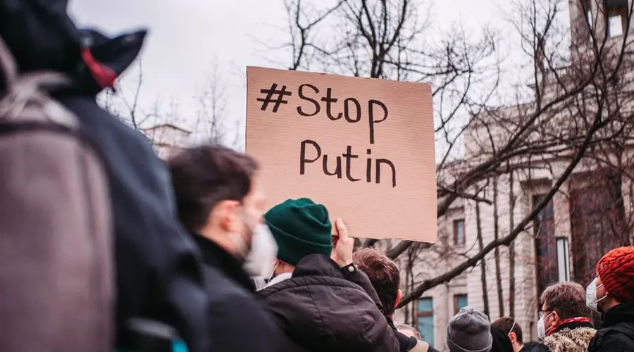People in Berlin protest against Putin with anti-war signs, showing unity for peace.