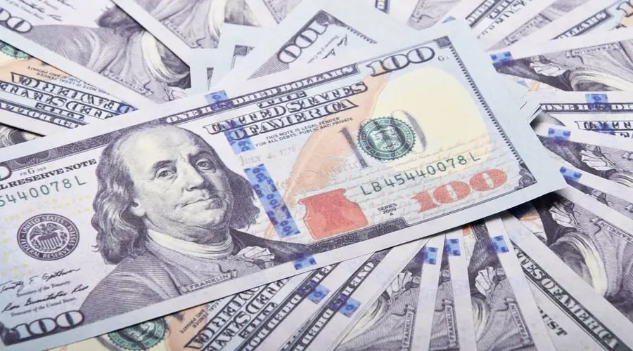 A stack of hundred dollar bills spread out, symbolizing wealth and financial success.