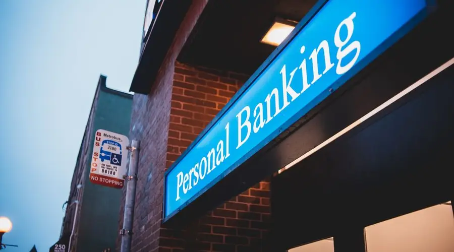 From below of bright blue signboard saying personal banking on modern building of town