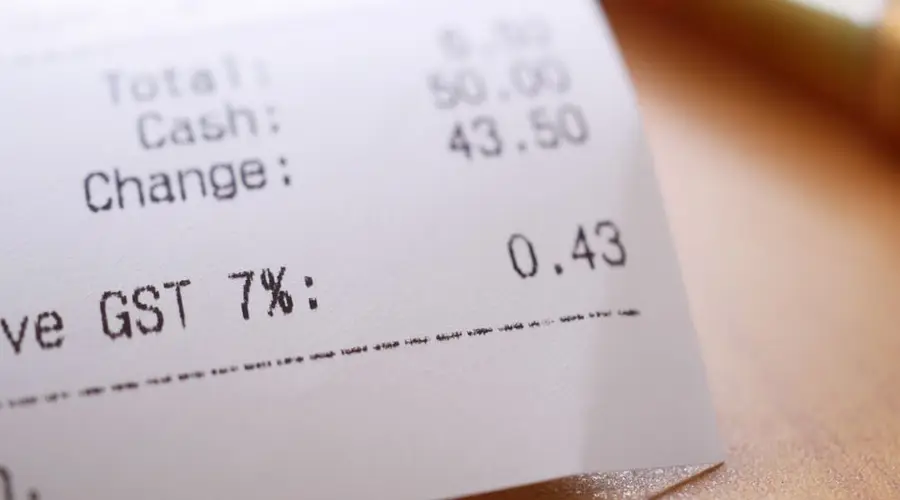Detailed close-up image of a shopping receipt showing GST and total changes.