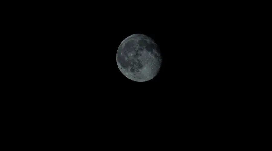 Detailed image of Earth's moon showing craters and shadows against the night sky.