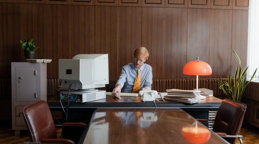 Businessman working in a retro office with vintage computer and decor.