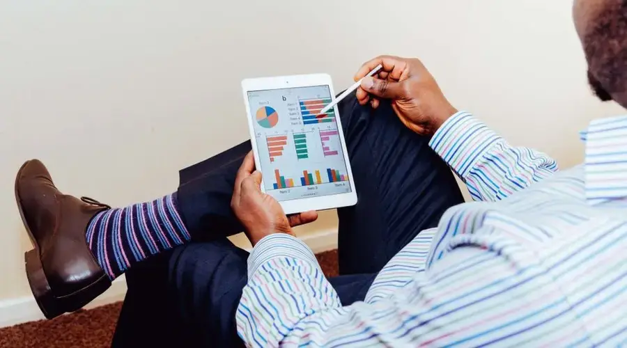 Businessman using a tablet for data analysis in a relaxed office setting.