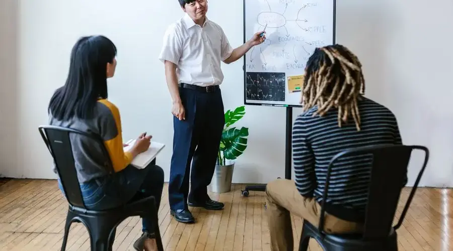 Three people in an indoor meeting discussing cryptocurrency and blockchain strategies.