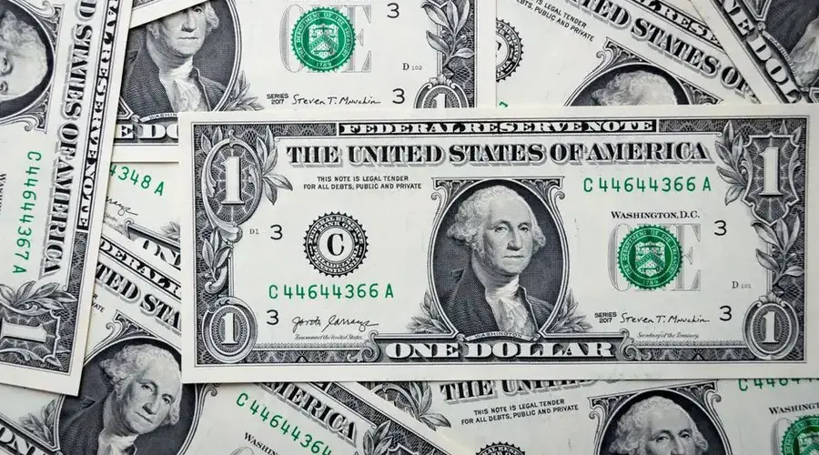 Detailed close-up of multiple one dollar bills showcasing U.S. currency design.