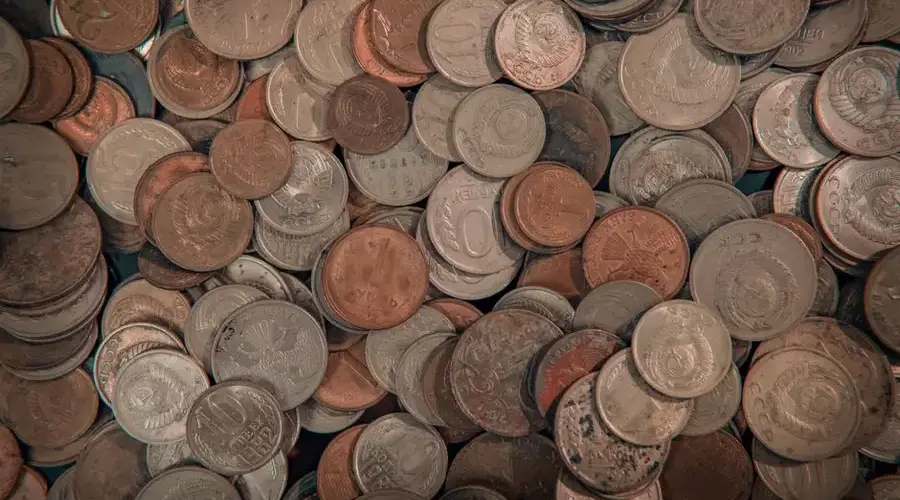 Close-up view of assorted foreign coins in a large mixed pile, perfect for finance-related projects.