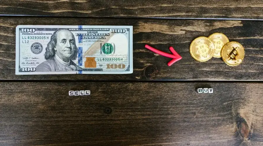 Bitcoin coins and a dollar bill symbolize digital and traditional currency trade.