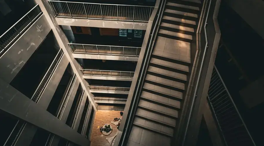 A dramatic view of a modern, multi-level staircase and atrium with a perspective from above.