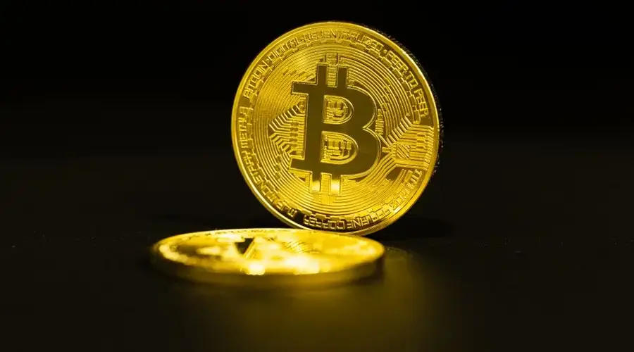 Close-up of gold Bitcoin coins on a dark background, symbolizing cryptocurrency.