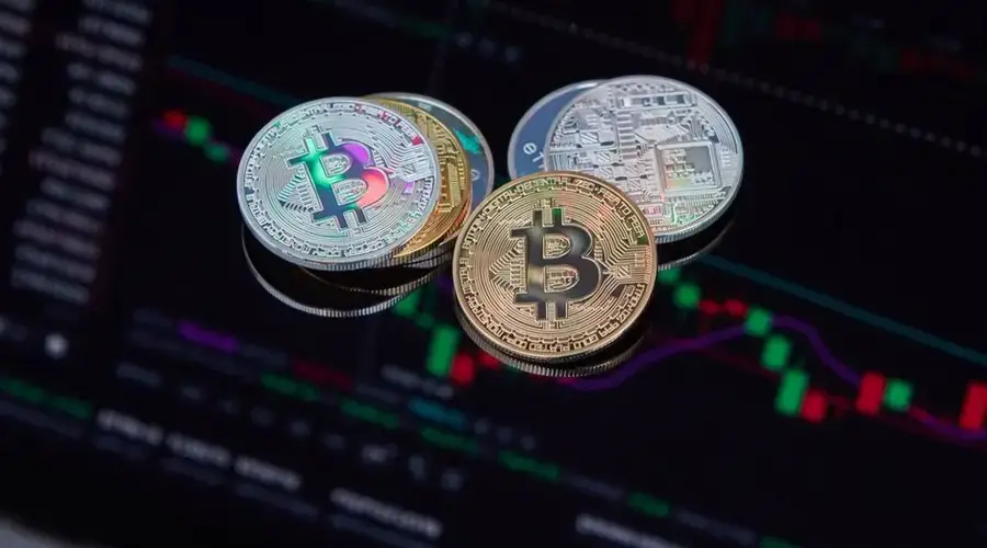 Close-up of Bitcoin cryptocurrency coins with a digital market chart background, symbolizing finance and technology trends.